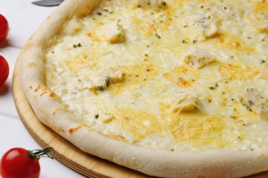 Pizza Dört peynir beyaz ahşap masada.