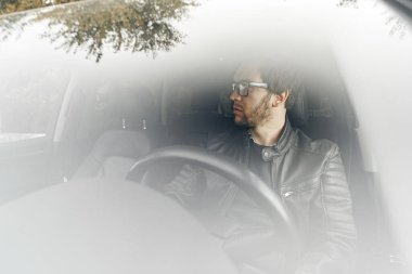 Arabada oturan kendinden emin genç adam.