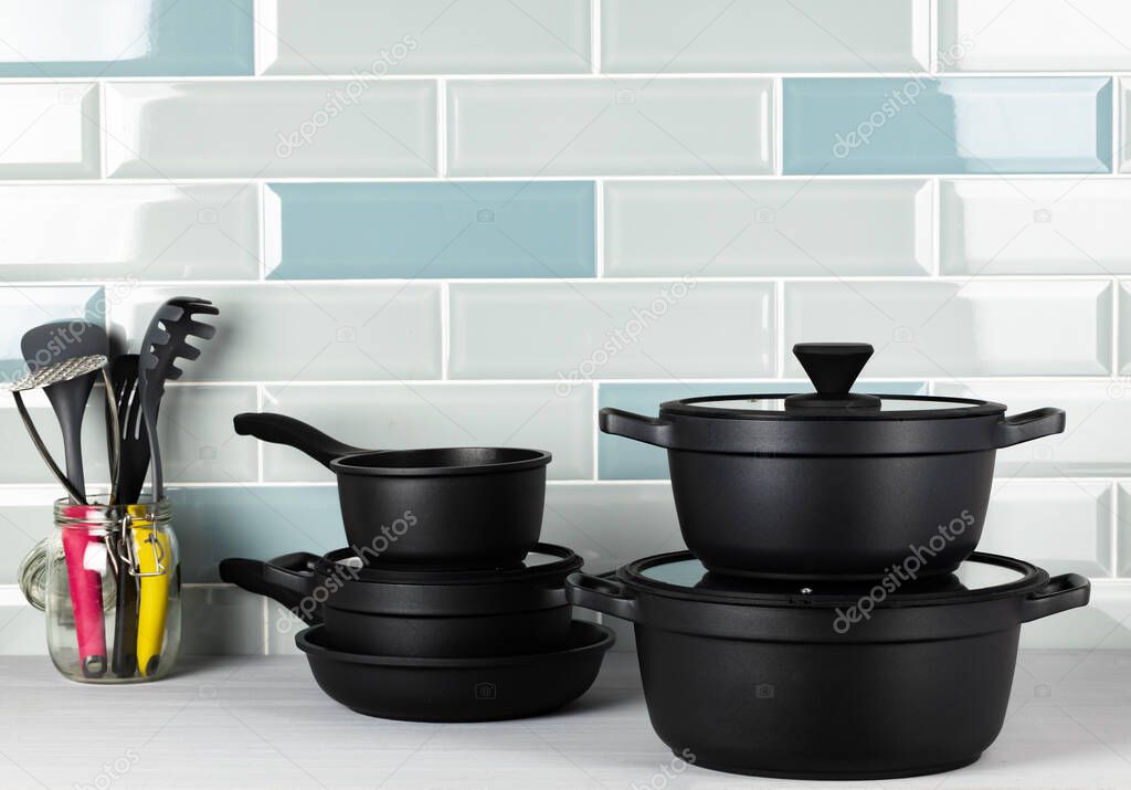New black cookware against blue tile wall