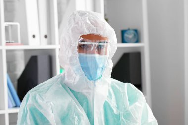 Klinikte koruyucu tıp üniformalı erkek doktor