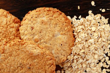 Tahta yüzeyde yulaf kurabiyeleri ve yulaf ezmesi.