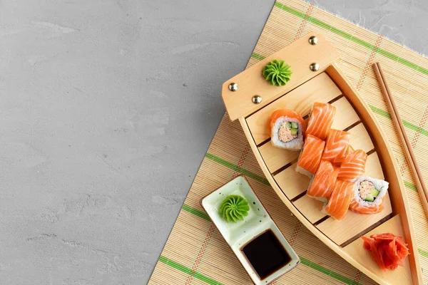 Sushi rolka pokrytá čerstvým lososem podávaná na talíři — Stock fotografie