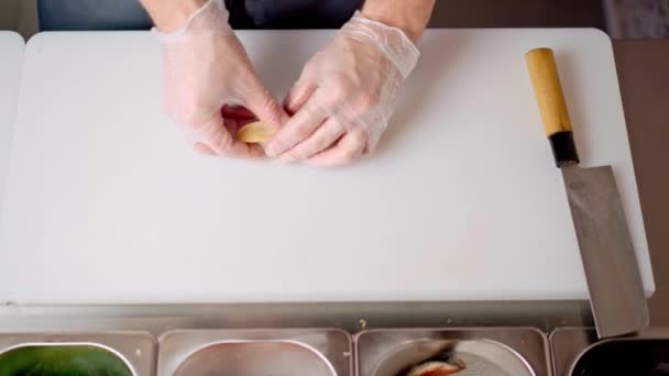 Manos de chef masculino cocinando sushi nigiri en pizarra blanca de cerca — Vídeo de stock