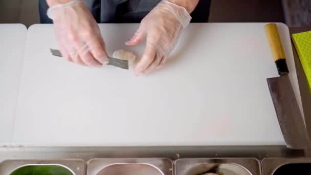 Ręce szefa kuchni gotowanie nigiri sushi na białej planszy zbliżenie — Wideo stockowe