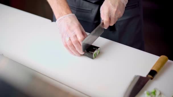 Chef masculino manos corte preparado maki sushi roll a bordo en la cocina del restaurante — Vídeos de Stock