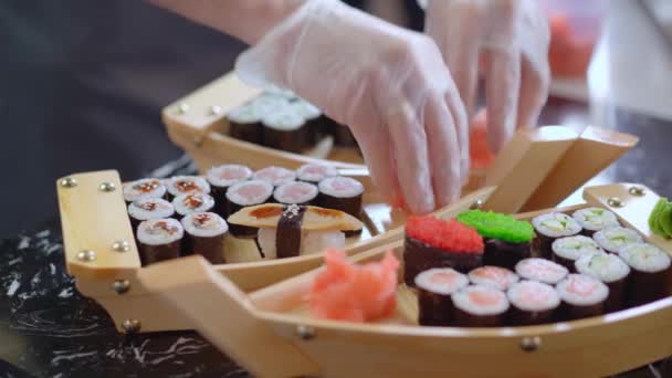 Chef zet sushi broodjes op houten boot plaat klaar om te worden geserveerd — Stockvideo