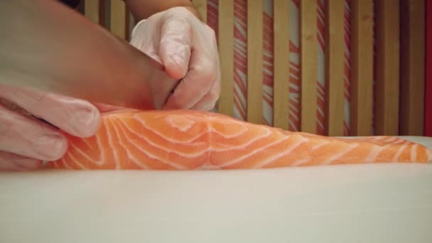 Человек готовить резки сырого лосося филе на борту близко — стоковое видео
