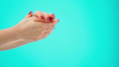 Mavi arka plana el kremi süren kadın eller