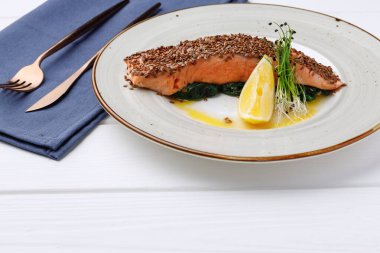 Beyaz ahşap masada kızarmış somon filetosu.