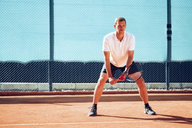 Tenis oyuncusu tenis kortunda hazır bekliyor.