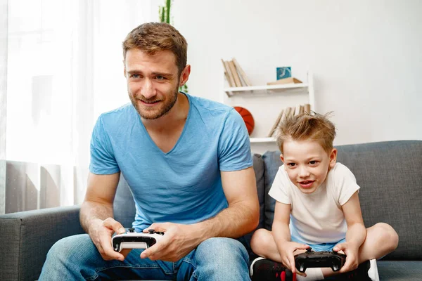 父と息子はビデオゲームを一緒に家で — ストック写真