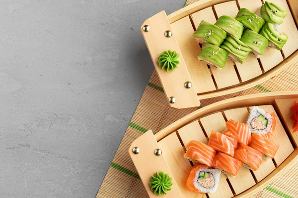 Rolo de sushi abacate e rolo com salmão servido em pratos de madeira — Fotografia de Stock