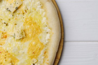 Pizza Dört peynir beyaz ahşap masada.