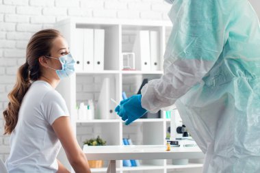 Doktor, hastaya hastanede aşı yapmaya hazırlanıyor.