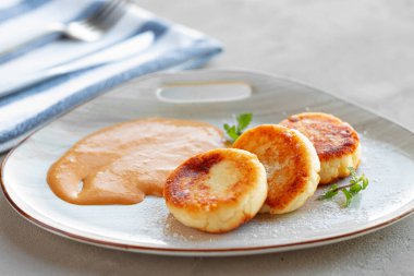 Rus peynirli kekleri sosla servis edilir.