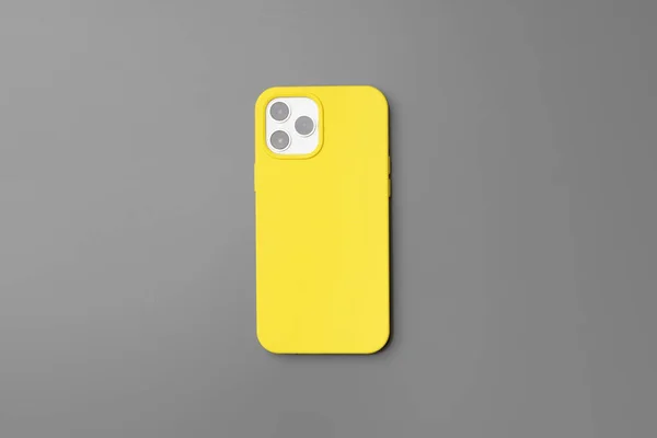 Smartphone moderne en boîtier jaune sur fond gris — Photo