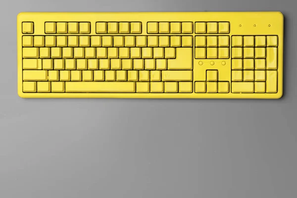 Teclado de computador amarelo no fundo cinza vista superior — Fotografia de Stock