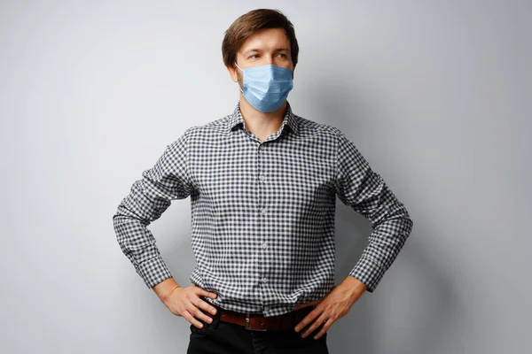 Man bär hygienisk mask mot grå bakgrund — Stockfoto