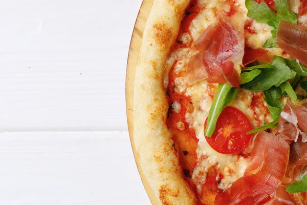 Pizza an Bord auf weißem Holztisch — Stockfoto