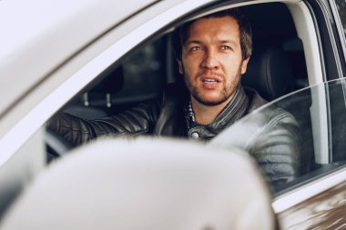 Arabada oturan kendinden emin genç adam.