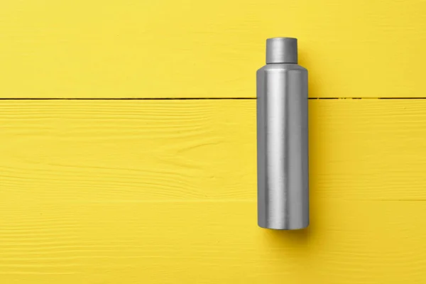 Grå kosmetisk flaska på gul trä bakgrund — Stockfoto