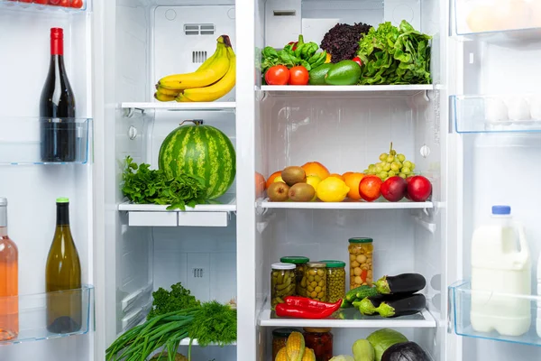 Nevera abierta llena de frutas, verduras y bebidas — Foto de Stock