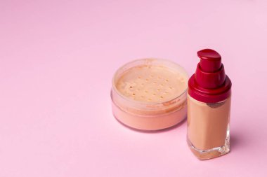 Pembe arka planda yüz rengi için kozmetik ürünler