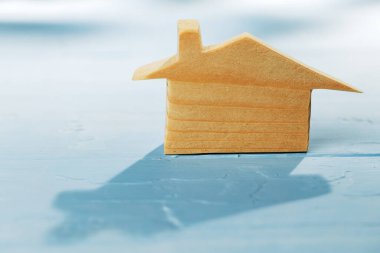 Mavi arka planda ahşap ev minyatürü. Yakın plan.