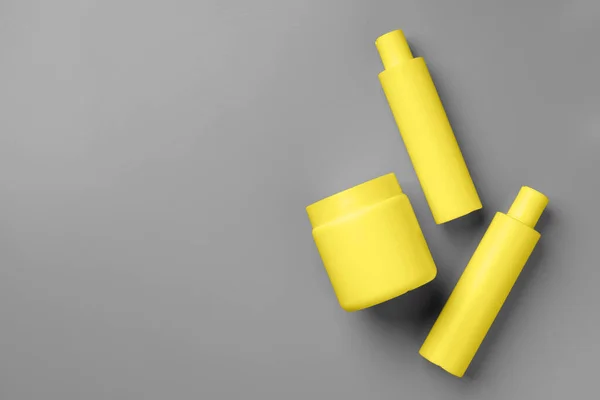 Yellow cosmetic container on gray background top view — Stock Photo, Image