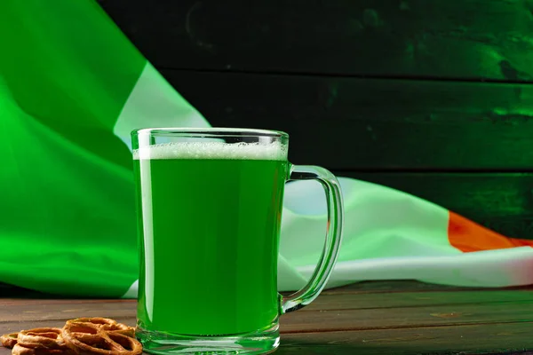 Bicchiere di birra verde contro bandiera irlandese — Foto Stock