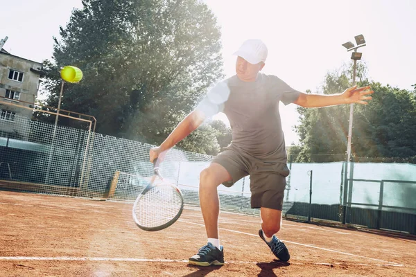 Mann mittleren Alters spielt Tennis im Freien — Stockfoto