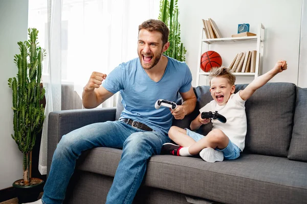 Father and his little son playing video games together at home — Stock Photo, Image