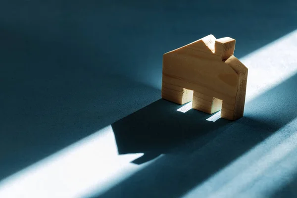 Mavi arka planı gölgeli minyatür ahşap bir ev. — Stok fotoğraf
