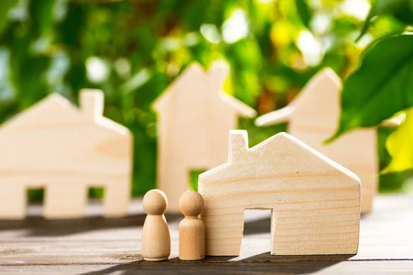 Maison jouet en bois et famille en bois sur fond de feuillage — Photo