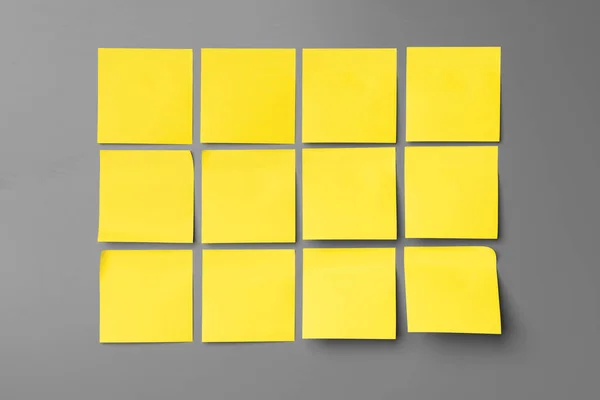 Adesivo amarelo notas no fundo cinza fechar — Fotografia de Stock