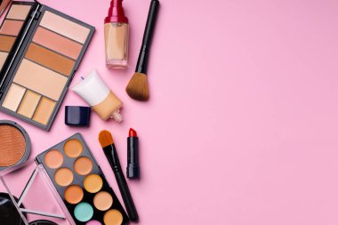 Cilt makyaj ürünleri ve pembe arka planda fırça