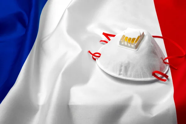 Medizinische Maske auf der französischen Nationalflagge — Stockfoto