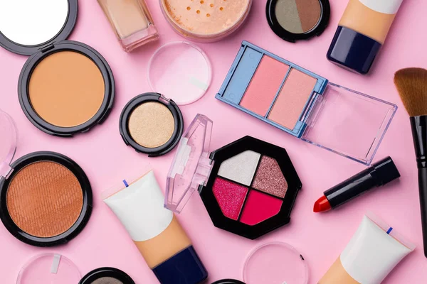 Complexión maquillaje productos y cepillo sobre fondo rosa — Foto de Stock