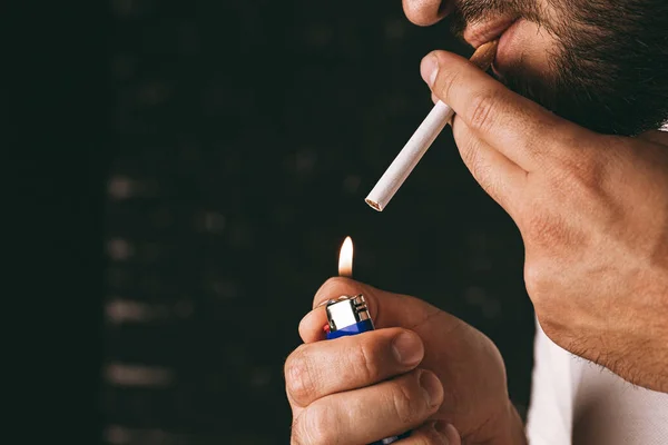 Hombre barbudo encendiendo cigarrillo con encendedor de fuego —  Fotos de Stock