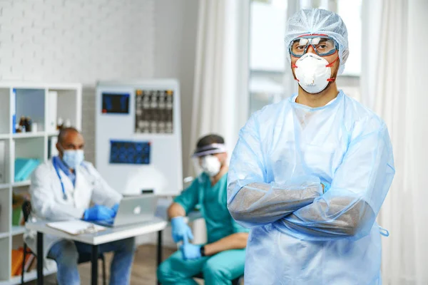 Hastane dolabında koruyucu önlüklü bir erkek doktor duruyor. — Stok fotoğraf