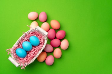 Yeşil arka planda bir yuvada paskalya yumurtaları