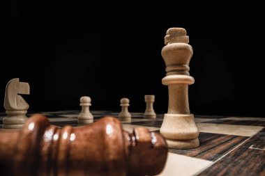 Siyah arkaplana karşı satranç taşlarıyla satranç oyunu