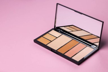 Pembe arka planda yüz rengi için kozmetik ürünler