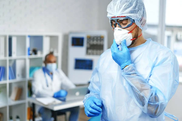 Männlicher Arzt in medizinischem Schutzanzug steht im Krankenhausschrank — Stockfoto