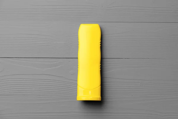 Gri arkaplan görünümlü sarı kozmetik kabı — Stok fotoğraf