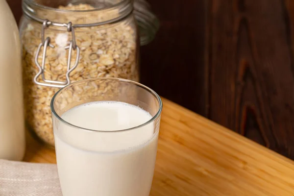 Vaso de leche y copos de avena sobre mesa de madera —  Fotos de Stock