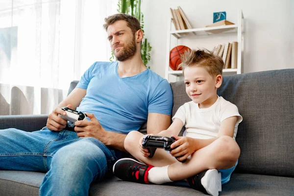 Батько і його маленький син грають у відеоігри вдома — стокове фото