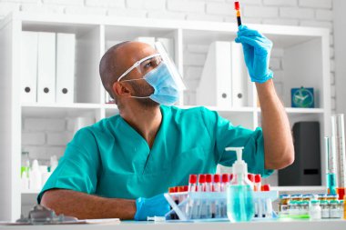 Afrikalı Amerikalı doktor veya laboratuvar çalışanı klinikte kan örneğini inceler.