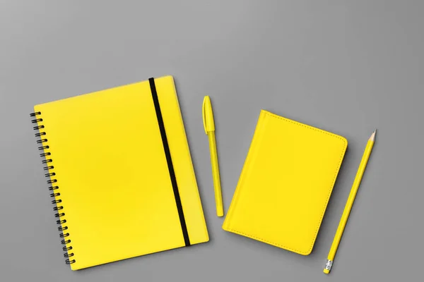 Yellow notepad with yellow pencil on gray background — Stock Photo, Image