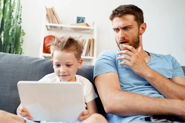 Padre preocupado mirando lo que su hijo está viendo en la tableta digital — Foto de Stock